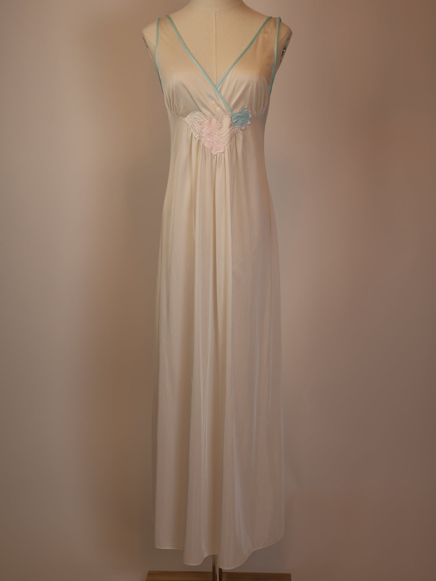 Full front view of 1970s white maxi slip dress with pastel floral appliqué and mint trim, vintage satin lingerie chemise