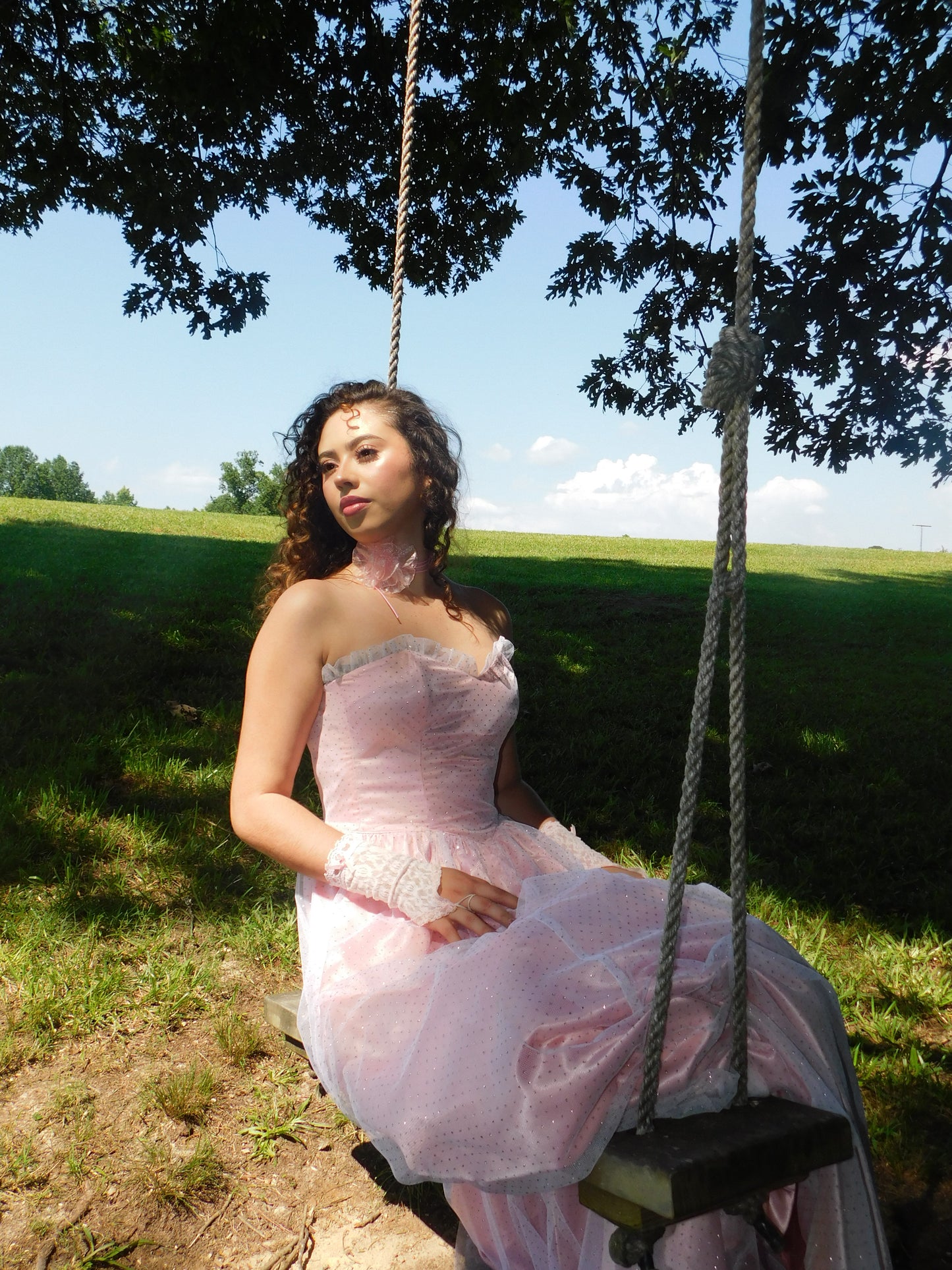 Full-length view of 1980s Gunne Sax dress with structured bodice and A-line skirt, modeled on rustic wooden swing.