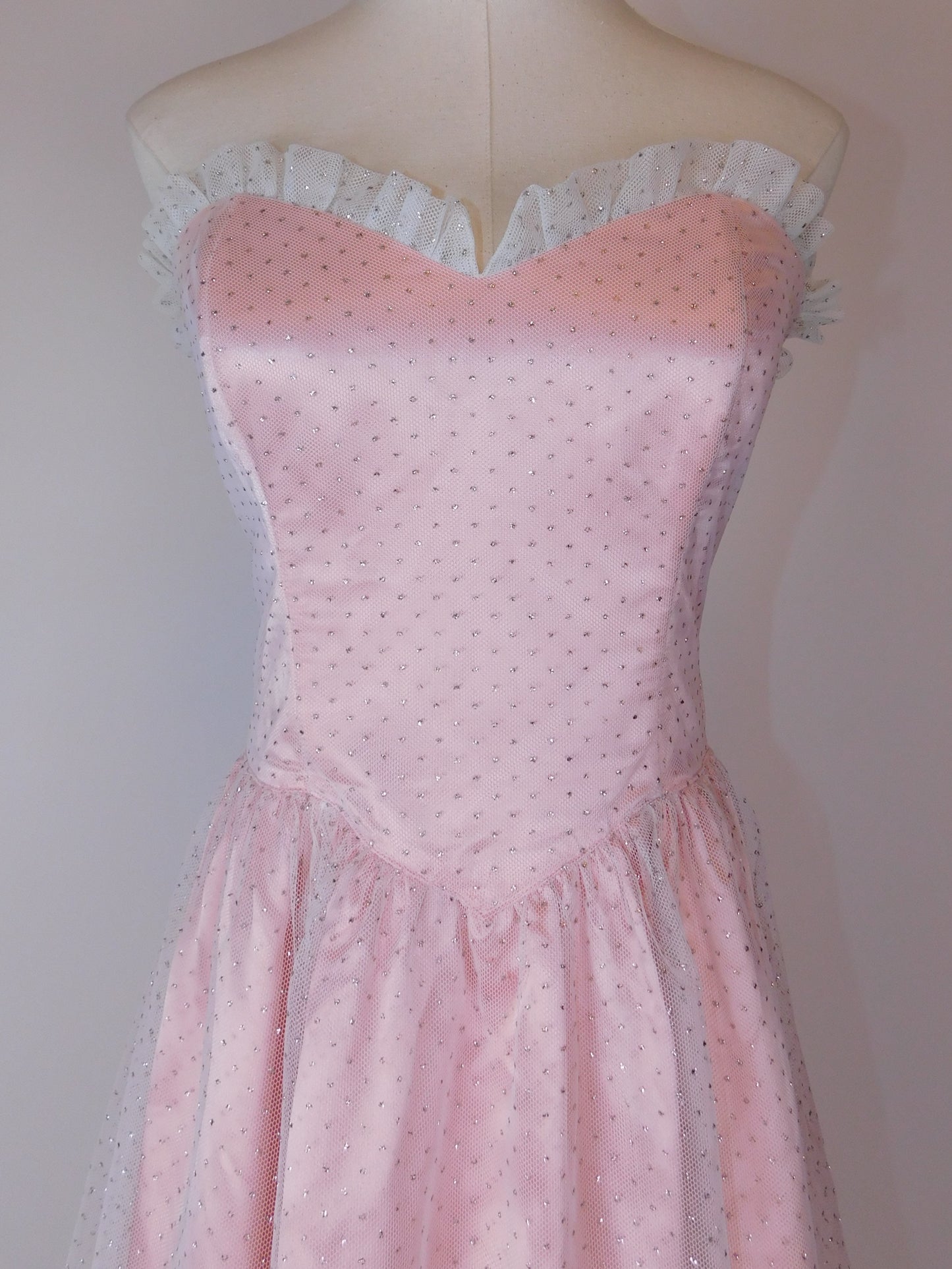 Detailed close-up of bodice on 1980s Jessica McClintock Gunne Sax pink satin strapless gown with lace neckline