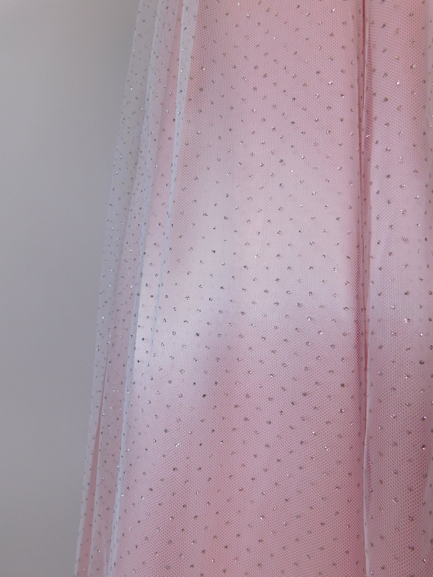Fabric close-up of 1980s Gunne Sax Jessica McClintock pink satin gown showing glittered tulle overlay and polka dots