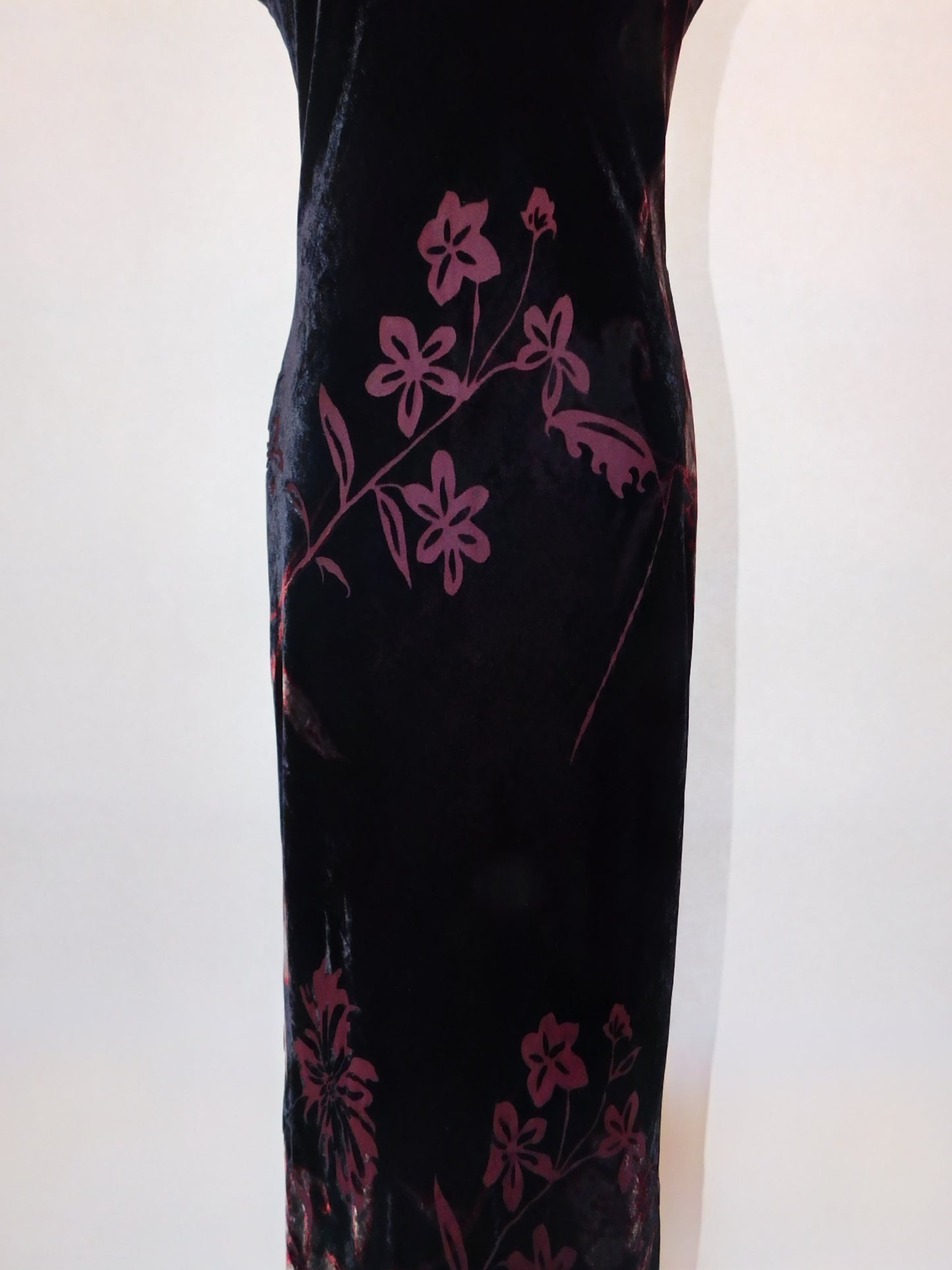 Detail of lower half of 90s velvet gown showing burgundy floral burnout design on black silk base