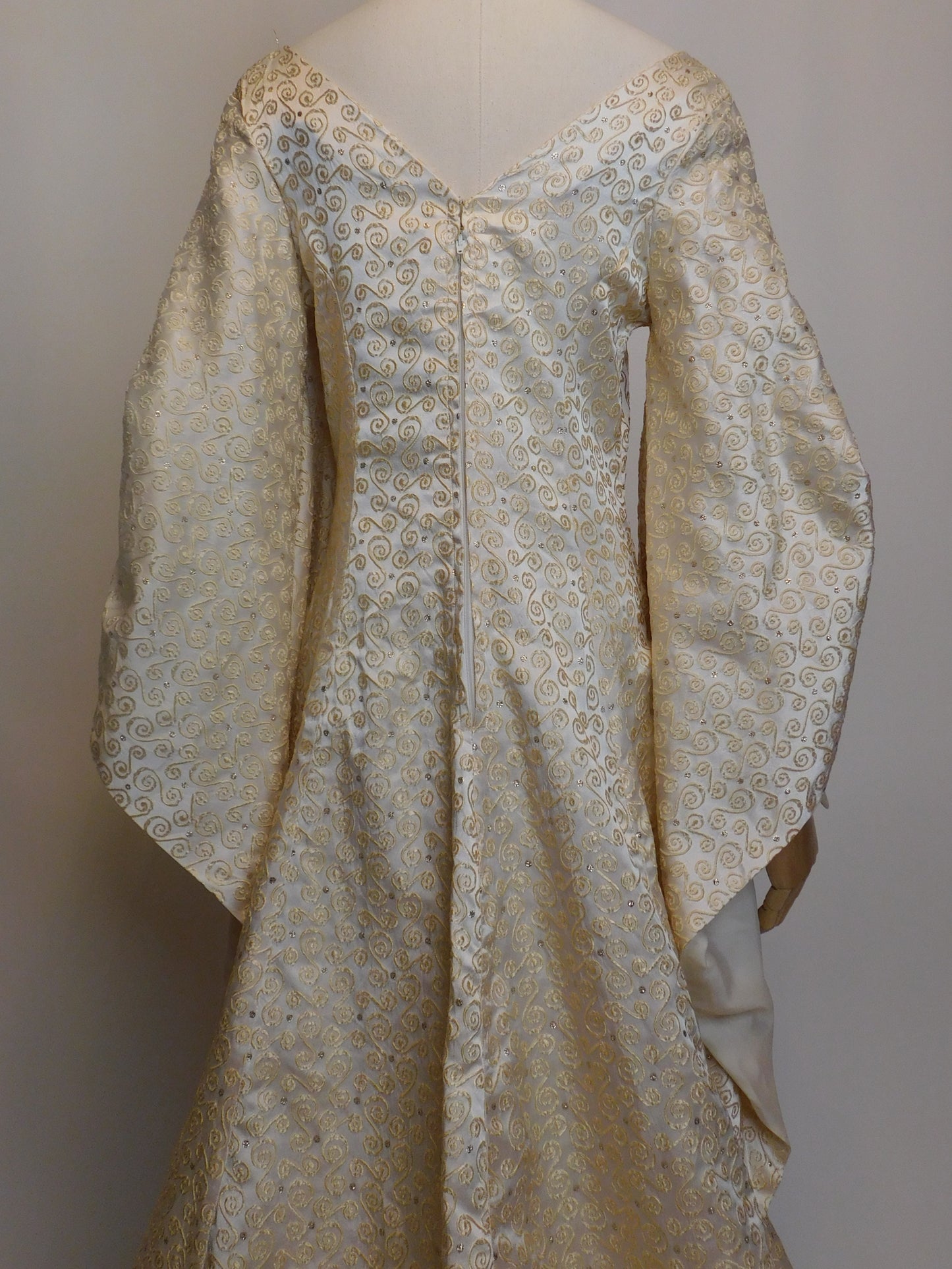 Mid-back detail of the vintage 1930s Spanish silk gown, highlighting the subtle V-neckline, center zipper closure, and gold scroll embroidery on pearl-toned silk.