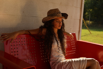 Vintage ivory satin lace slip dress from 1990s styled with western boots and straw hat, photographed in rustic country porch