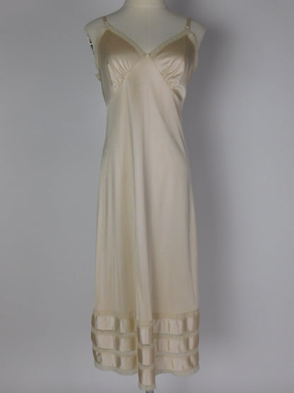 Full front view of 1990s ivory satin slip dress with lace trim, V neckline and silky bias cut on mannequin against neutral backdrop