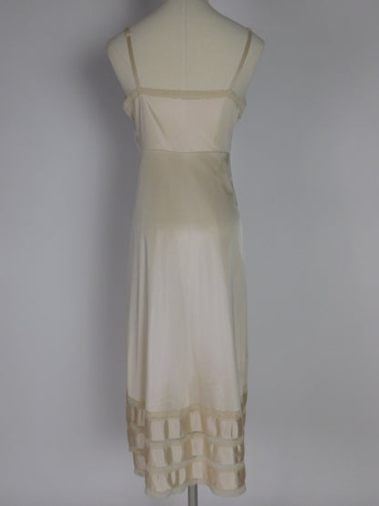Back view of 1990s ivory satin lace slip dress displayed on mannequin, featuring simple straps and smooth satin finish