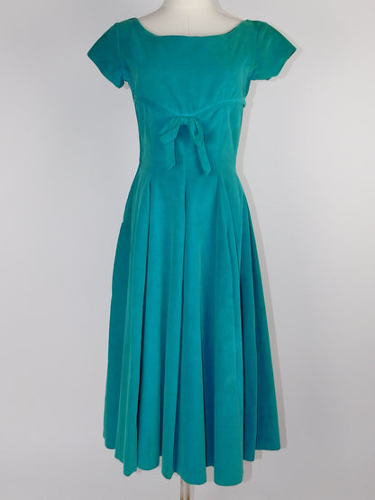 Vintage teal velvet dress styled on mannequin, back view with dart seams and fitted bodice