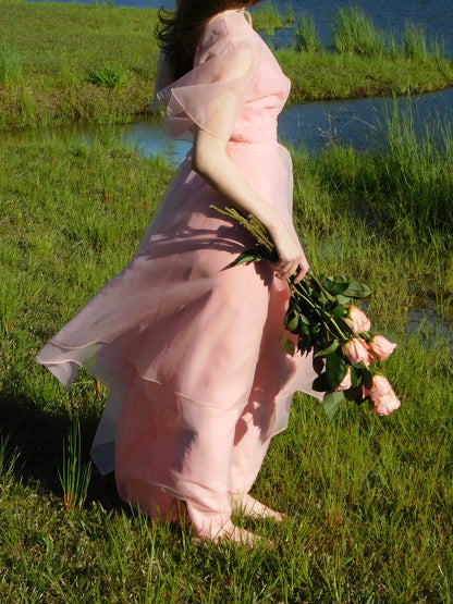 Side angle showing the layered train and sheer overlay of 1960s pink formal dress in sunlight.